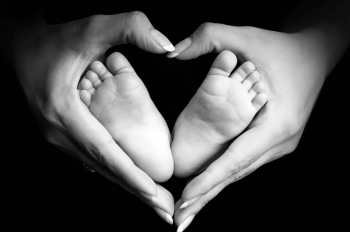womans hands around baby's feet