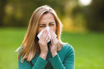 woman sneezing from pollen and dust mites